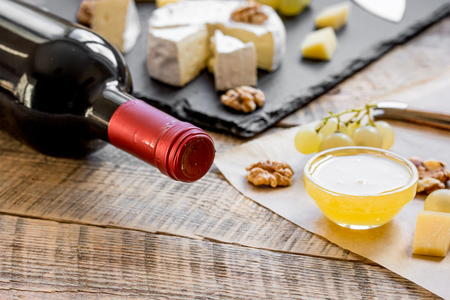 bottle of red wine, appetizers and corkscrew on wooden background.の写真素材
