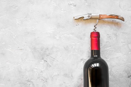 glass wine bottle and corkscrew on concrete background top view.の写真素材