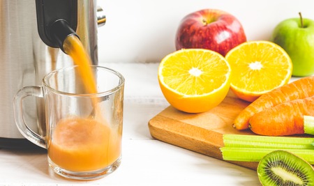 process of preparation of fresh juice in juicer close up