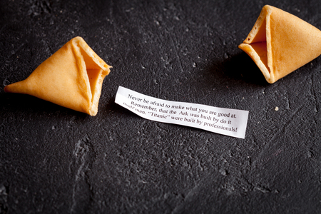 Chinese fortune cookie with prediction on dark background close up top viewの写真素材