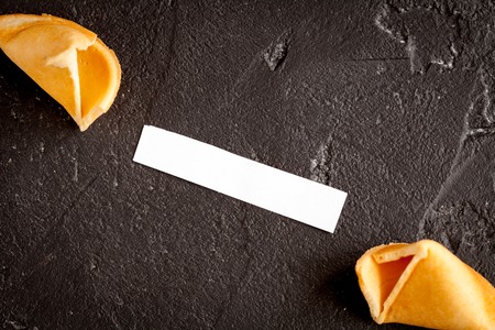 Chinese fortune cookie with prediction on dark background close up top viewの写真素材