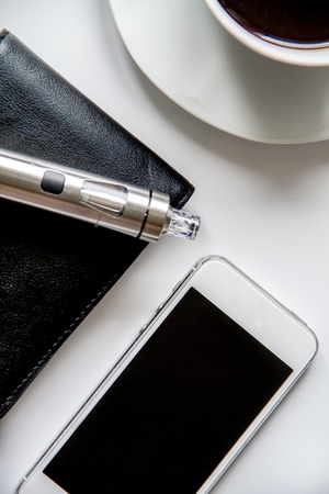 smartphone, electronic cigarette and men's accessories top view.