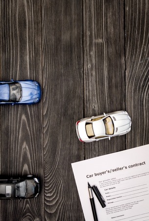 concept of buying car on dark wooden background top view.の写真素材