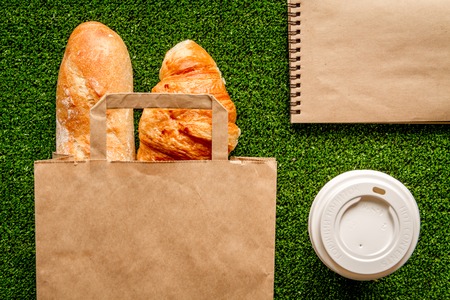 take out in paper bag on green background top view.の写真素材
