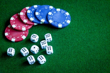 poker chips and dice on green background top view.