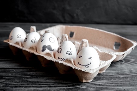 concept social networks communication and emotions - eggs smile on dark wooden backgroundの写真素材