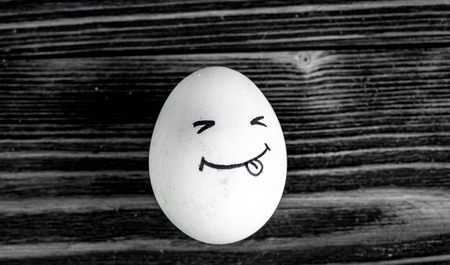 concept human relationships and emotions eggs - smile on dark wooden backgroundの写真素材