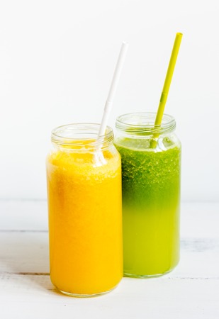 Fresh detox juices in glass bottles on white background.の写真素材