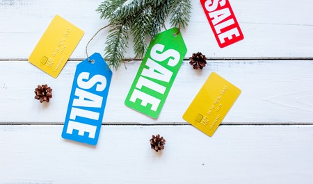 winter clothing sale on wooden background top view.
