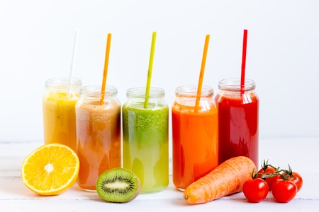 Fresh detox juices in glass bottles on white background.の写真素材