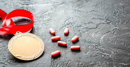 Concept of doping in sport - deprivation medals close up on dark backgroundの写真素材