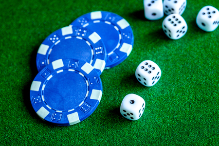 poker chips and dice on green background top view.の写真素材