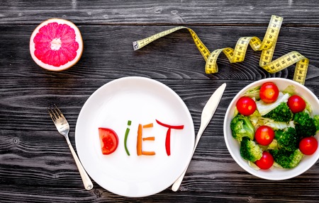 concept slimming diet fresh vegetables on dark wooden background top view.の写真素材