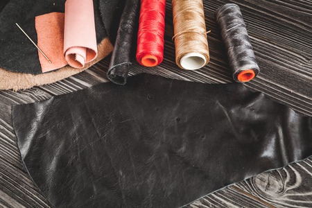 Instruments in leather shop on dark wooden background top view.の写真素材