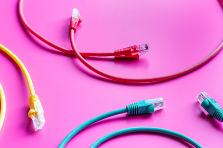 concept network internet cable on pink background close up.
