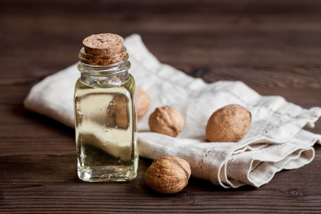cosmetic and therapeutic walnut oil on dark wooden background.の写真素材