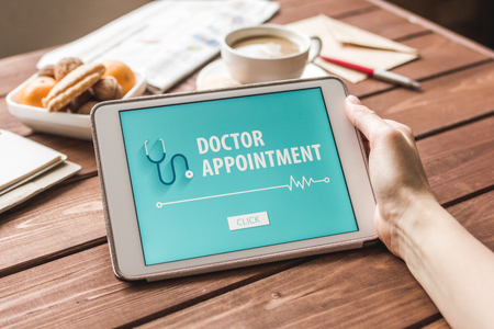 concept of appointment to doctor online on wooden backgroundの写真素材