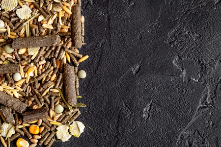 dry food for rodents on dark background top view.