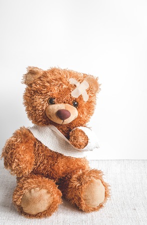 concept teddy bear childhood diseases at textile background close upの写真素材