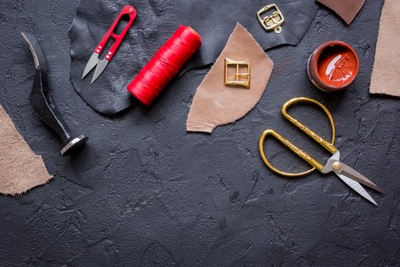 leather craft instruments on dark background top view mock up.の写真素材