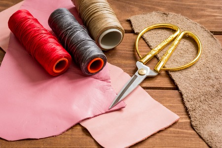 leather craft instruments on wooden background close up.