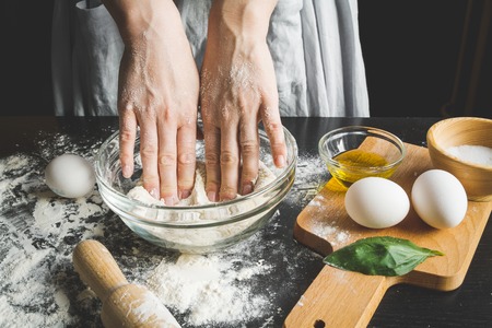 cooking pasta by chef in kitchen on dark backgroundの写真素材