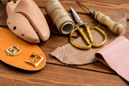 leather craft instruments on wooden background close up