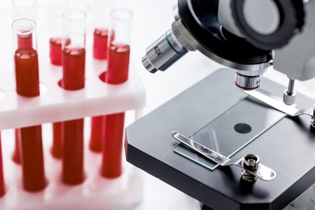 close up macro microscope with blood sample, tubes on white background.の写真素材