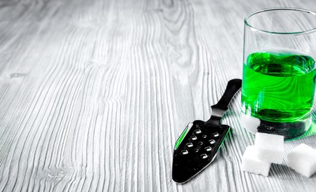 absinthe with sugar cubes and spoon on wooden backgroundの写真素材