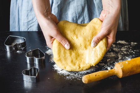 cooking homemade cookies with hands on dark background.の写真素材