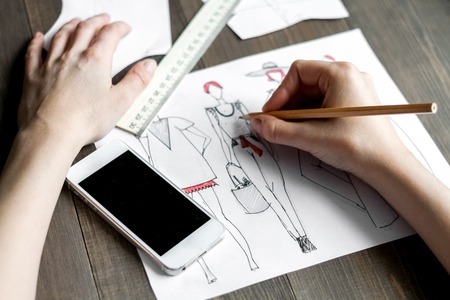 desktop designer clothes with tools at wooden tableの写真素材