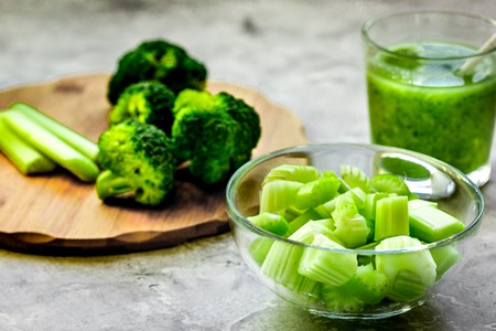 Green vegetable smoothie in glass at gray backgroundの写真素材