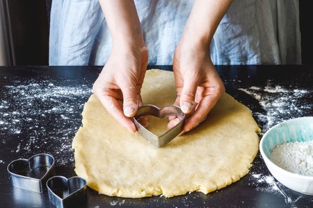 cooking homemade cookies with hands on dark backgroundの写真素材