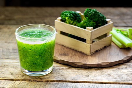 Green vegetable smoothie in glass at wooden backgroundの写真素材