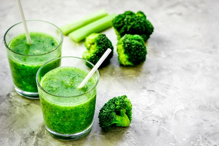 Green vegetable smoothie in glass at gray backgroundの写真素材