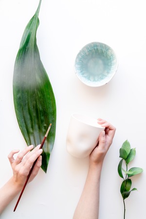 Painted ceramic cup on white layout top view.の写真素材