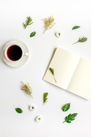 Copybook, americano and flowers on white table top view mock-upの写真素材