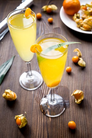 cocktail with physalis in glass on wooden backgroundの写真素材