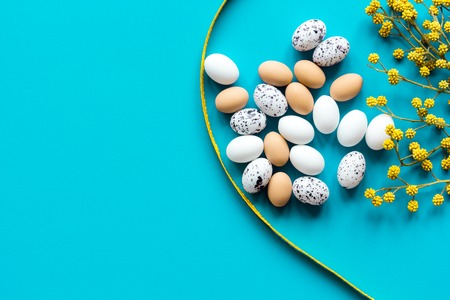 Easter eggs with blossom branch on blue background top view mockup