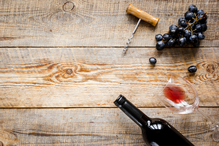 Glass of red wine and bottle on wooden background top view mock-upの写真素材