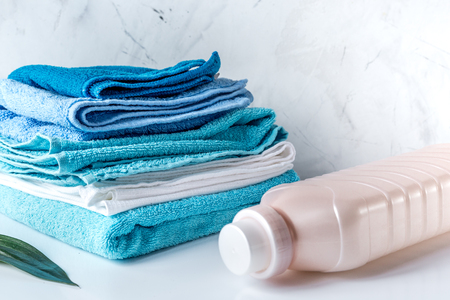 housekeeping set with towels and plastic bottles on laundry backgroundの写真素材