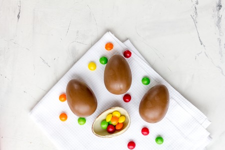 Easter chocolate eggs top view on stone background mock up