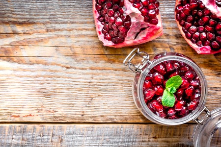 sliced pomegranate on wooden background top viewの写真素材