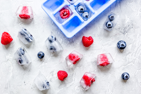 blueberry and raspberry in ice tray on stone background top viewの写真素材