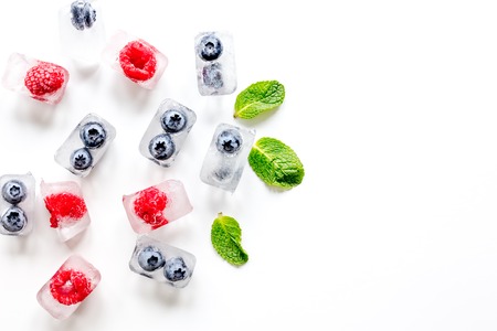 ice cubes with fresh berries on white background top view mock upの写真素材