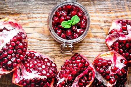 sliced pomegranate on wooden background top viewの写真素材