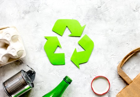 waste recycling symbol with garbage on stone background top view mockupの写真素材