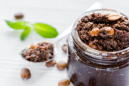 Homemade cosmetics with coffee scrub on white desk backgroundの写真素材