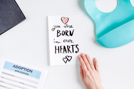 Adoption concept with card and application on white table background top viewの写真素材