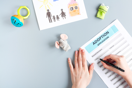 adoption form with hands in family concept on gray background top view mock-upの写真素材